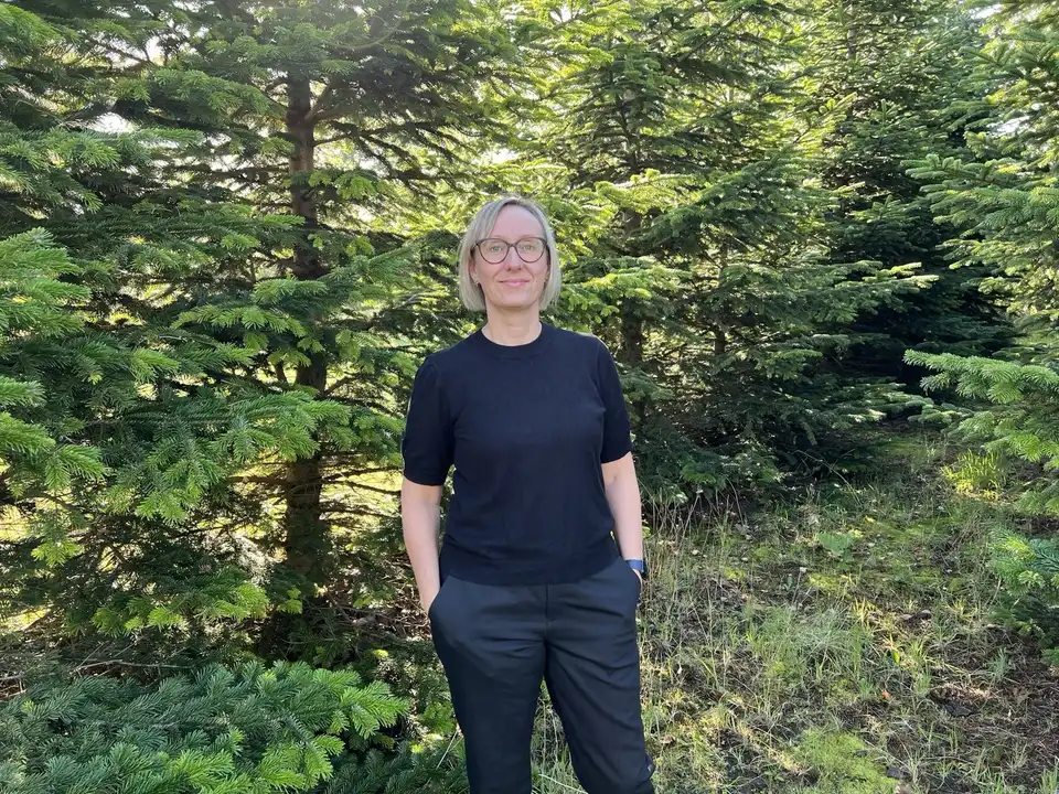 Ditte Immersen Dalgaard, indehaver af Farsø Begravelsesforretning, ved granerne
